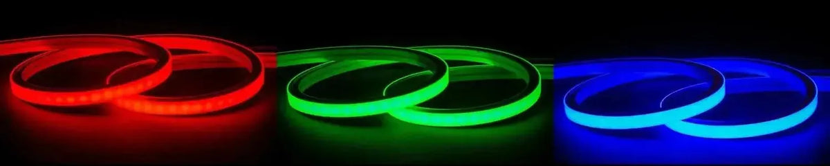 Flexible silicone RGB LED strip lights coiled in vibrant red, green and blue neon glow against a dark background
