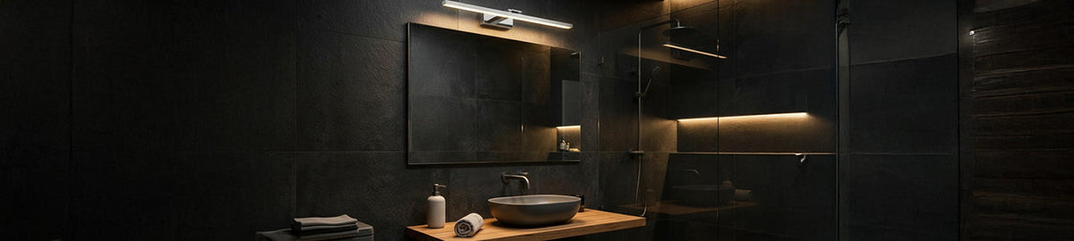 Modern chrome wall light mounted above a mirror in a dark tiled bathroom with a timber vanity and vessel basin