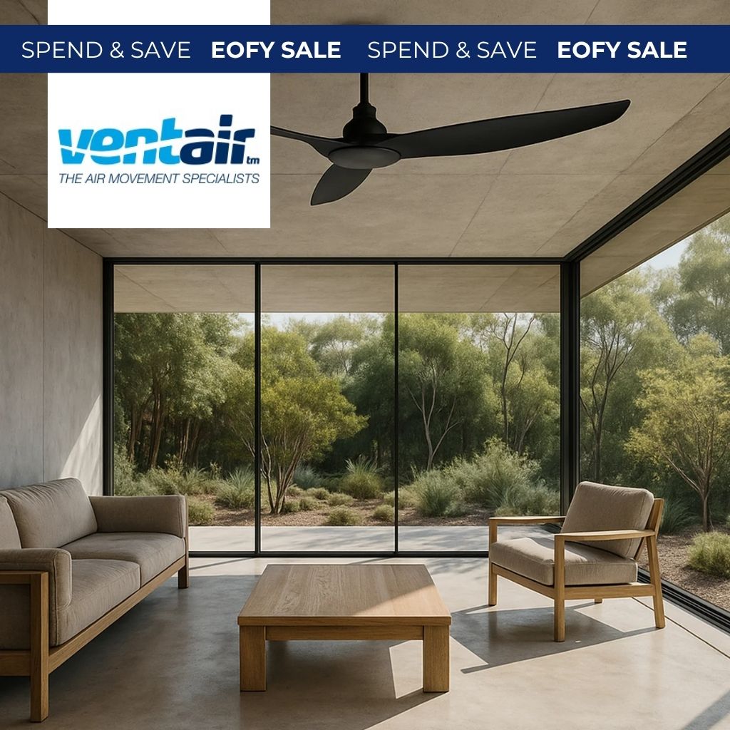 Matte black ceiling fan with three curved blades installed in a modern living room with concrete floors and garden views