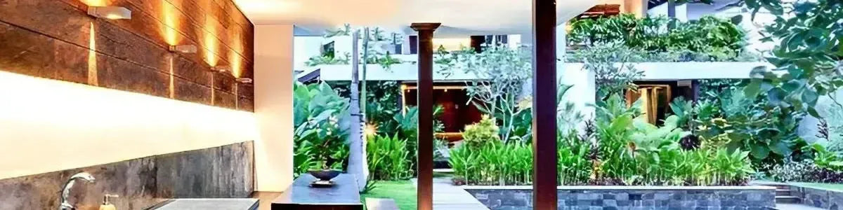 Modern stainless steel ceiling fan installed in a luxury tropical outdoor patio with lush garden views