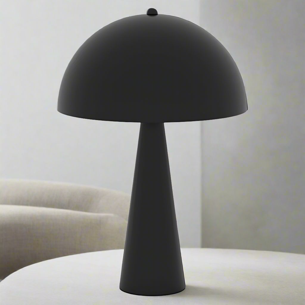 Matte black metal table lamp with a mushroom-inspired dome shade and sleek conical base on a white surface.